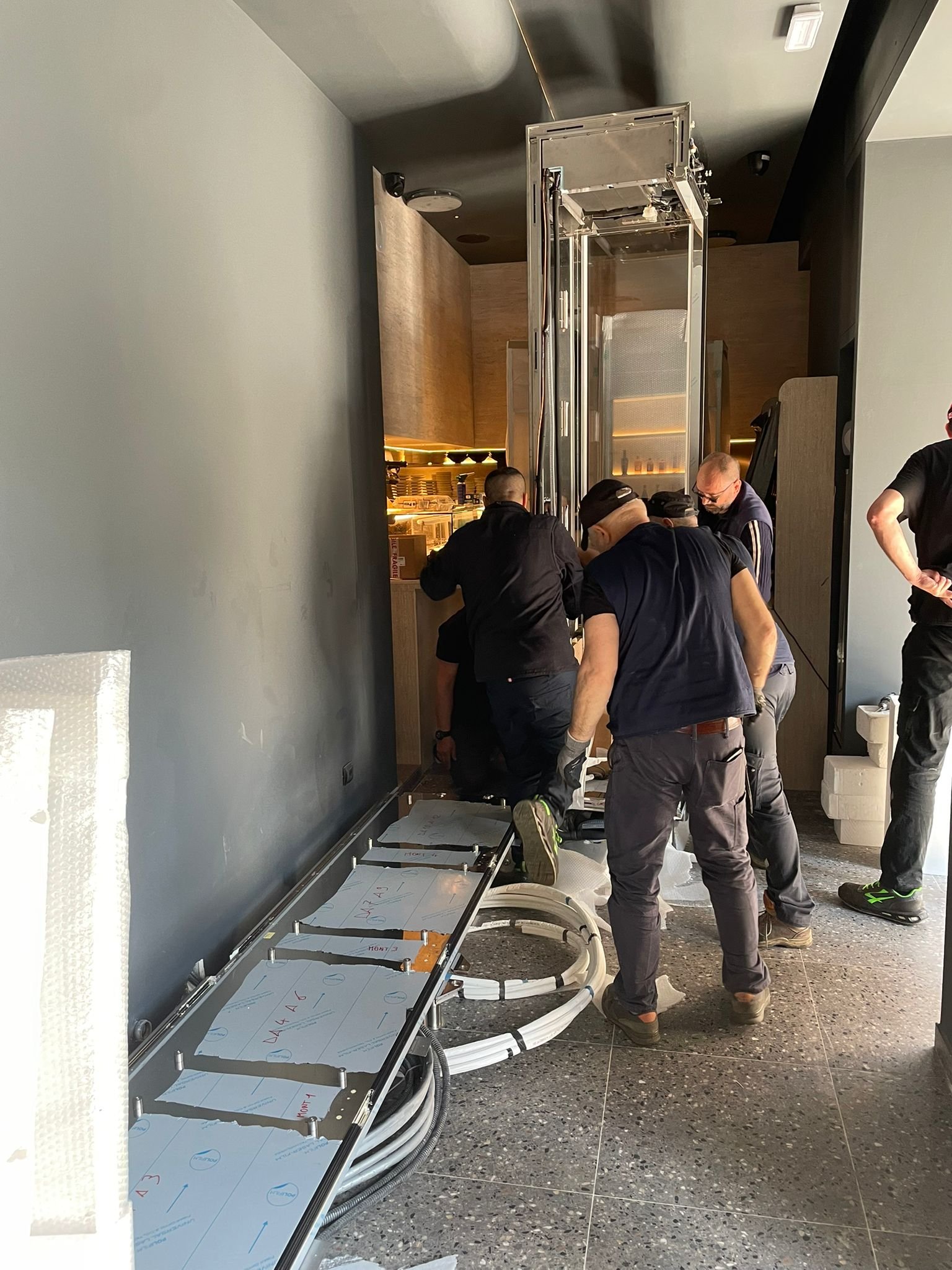 Posa della base della vetrina vino in Via Adige Milano - Team Italfrigo al lavoro